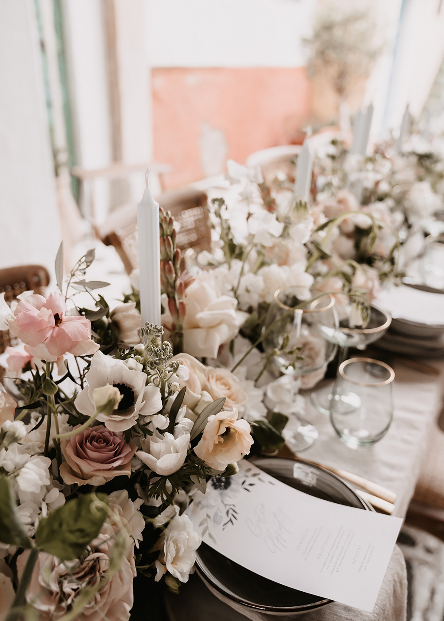 Der Hochzeitstisch mit Blumen geschmückt und mit den gedeckten Plätzen ist zu sehen. Die Blumen stechen durch ihre Vielfalt und unterschiedlichen Farben hervor.