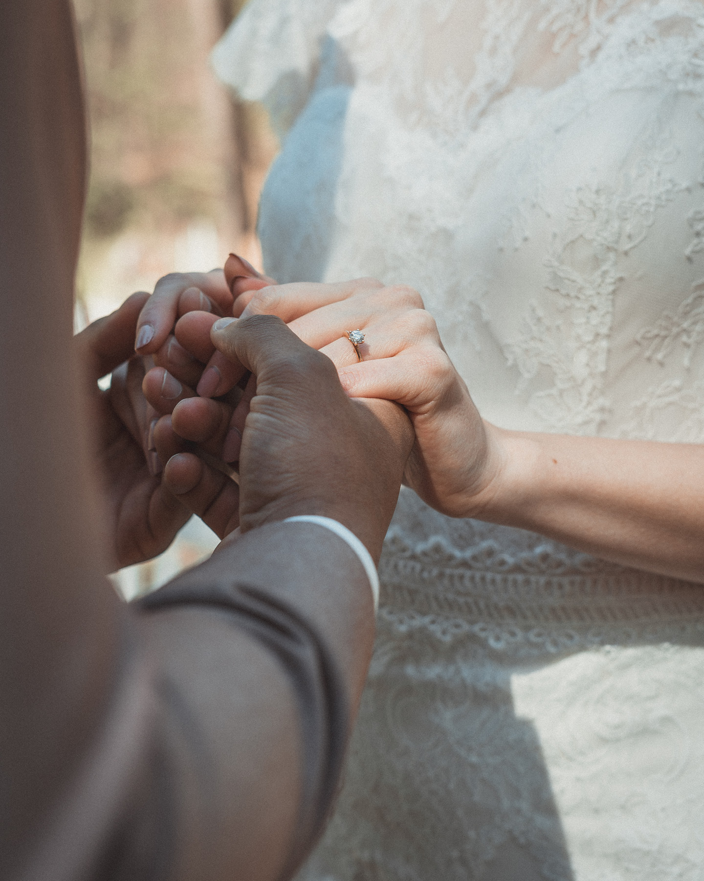 Bildausschnitt von Hochzeitspaar, dass sich an den Händen hält