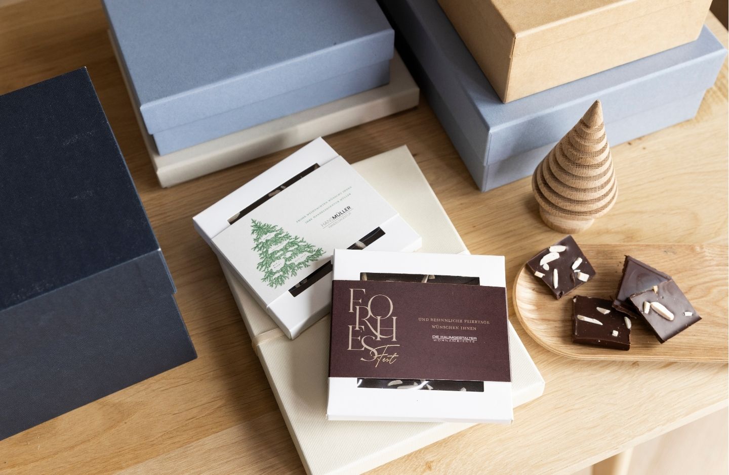 Schokoboxen mit personalisierter Banderole mit Geschenkboxen auf Holztisch