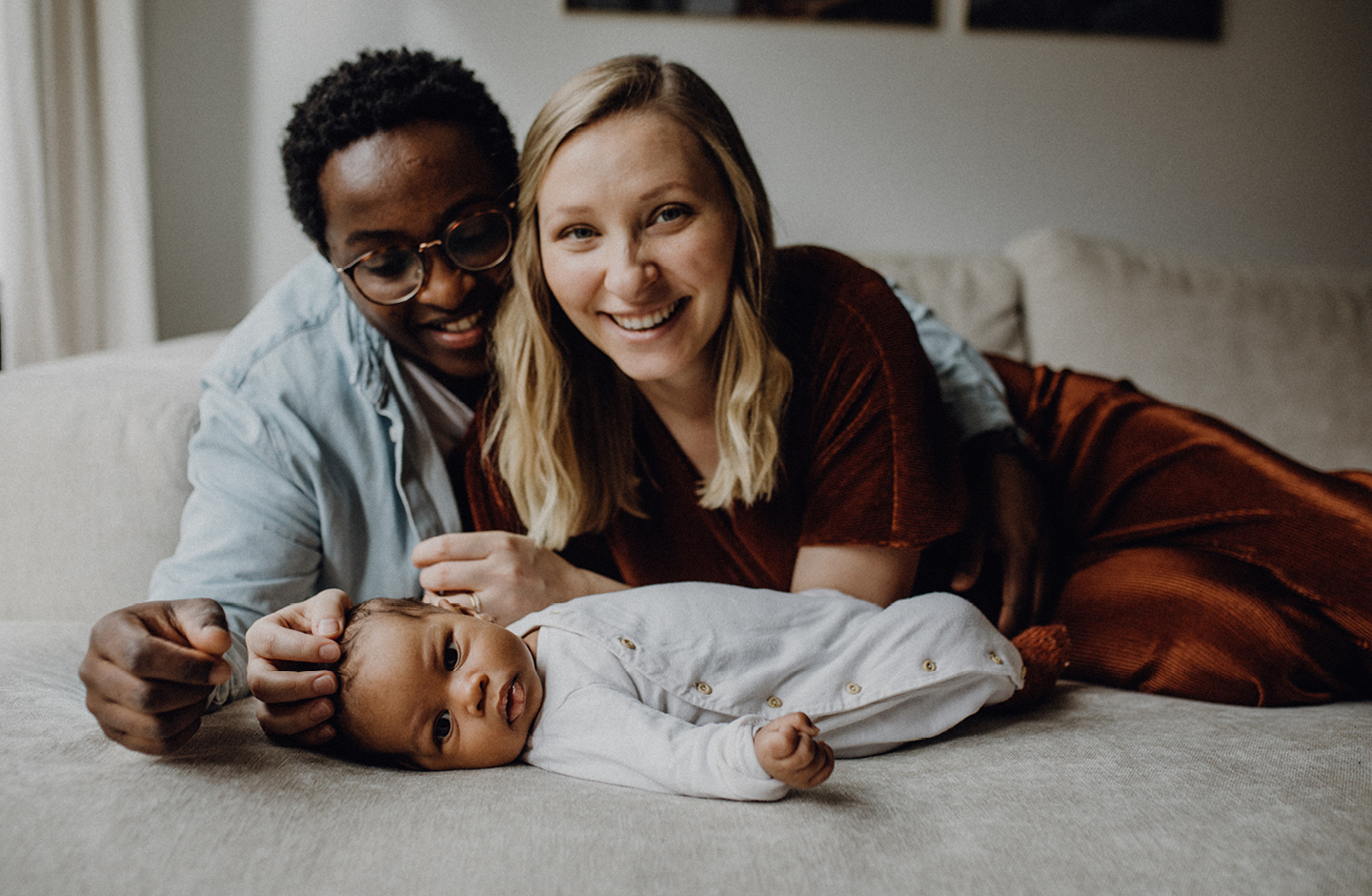 Vater und Mutter kuscheln mit Baby auf dem Bett