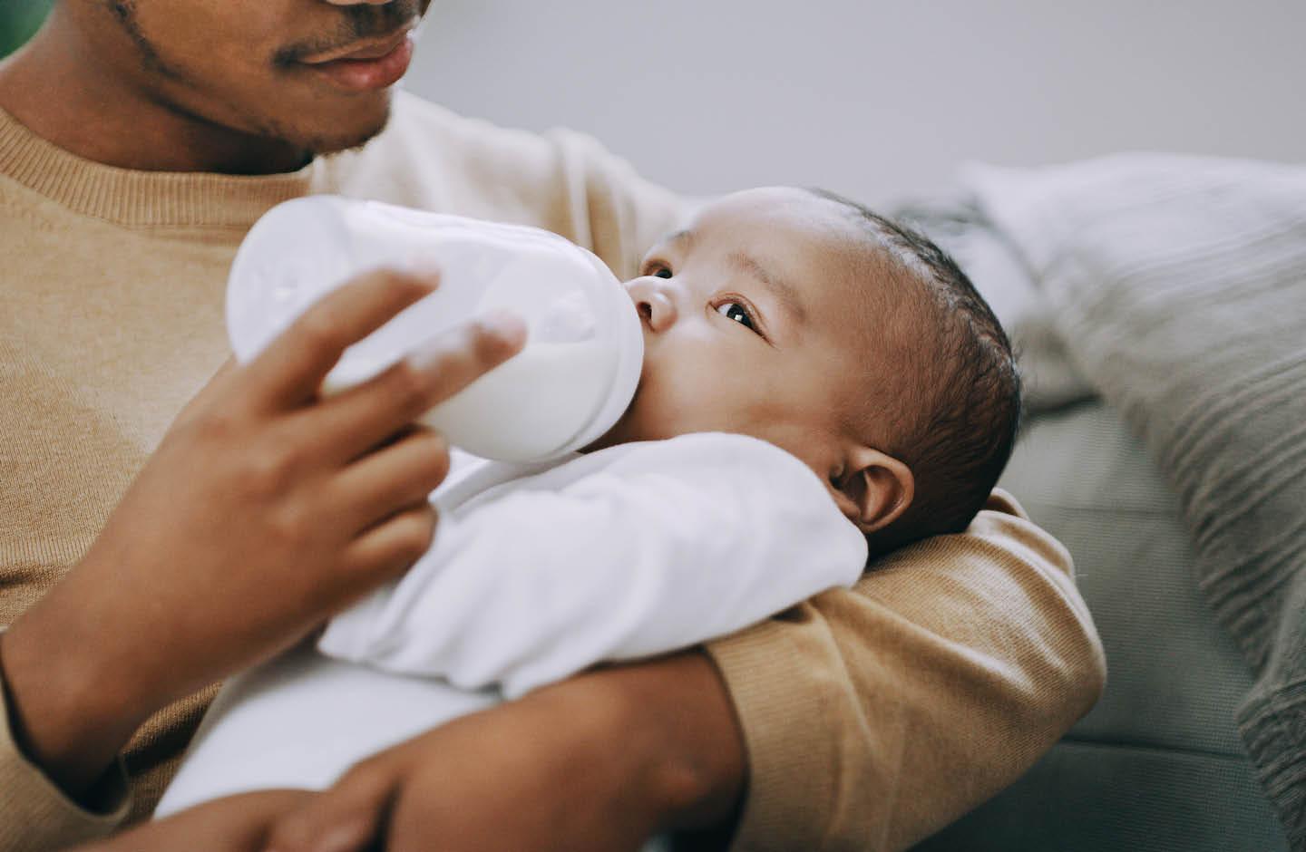 Junger Vater gibt seinem Baby die Flasche