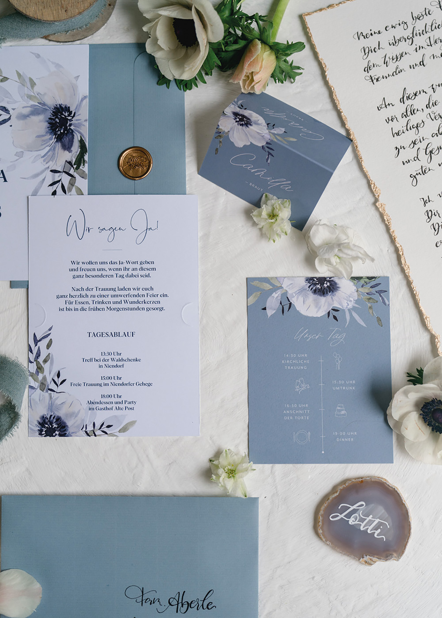 Die Hochzeitspapeterie des Paares wurde in hellblauen und weißen Tönen gestaltet. Auf der Papeterie findet sich eine detailtreu gezeichnete große Blüte in weiß und dunkelblau.