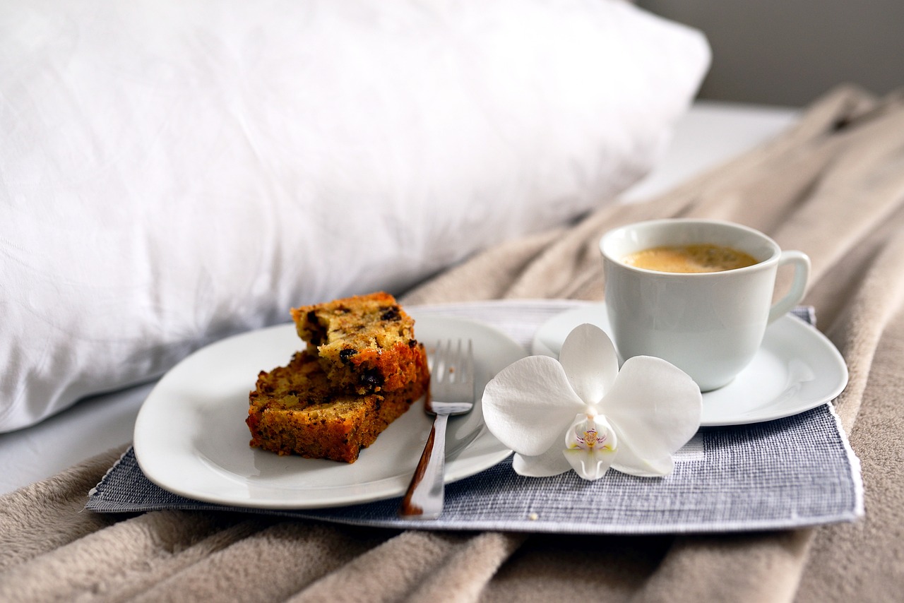 Kaffee und Kuchen mit Blume im Bett
