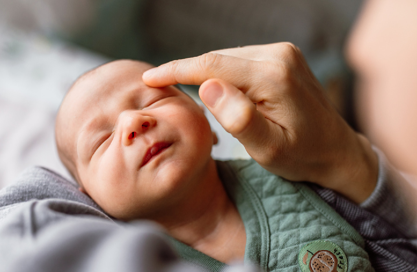 Mutter berührt ihr Baby zart mit ihrem Finger im Gesicht