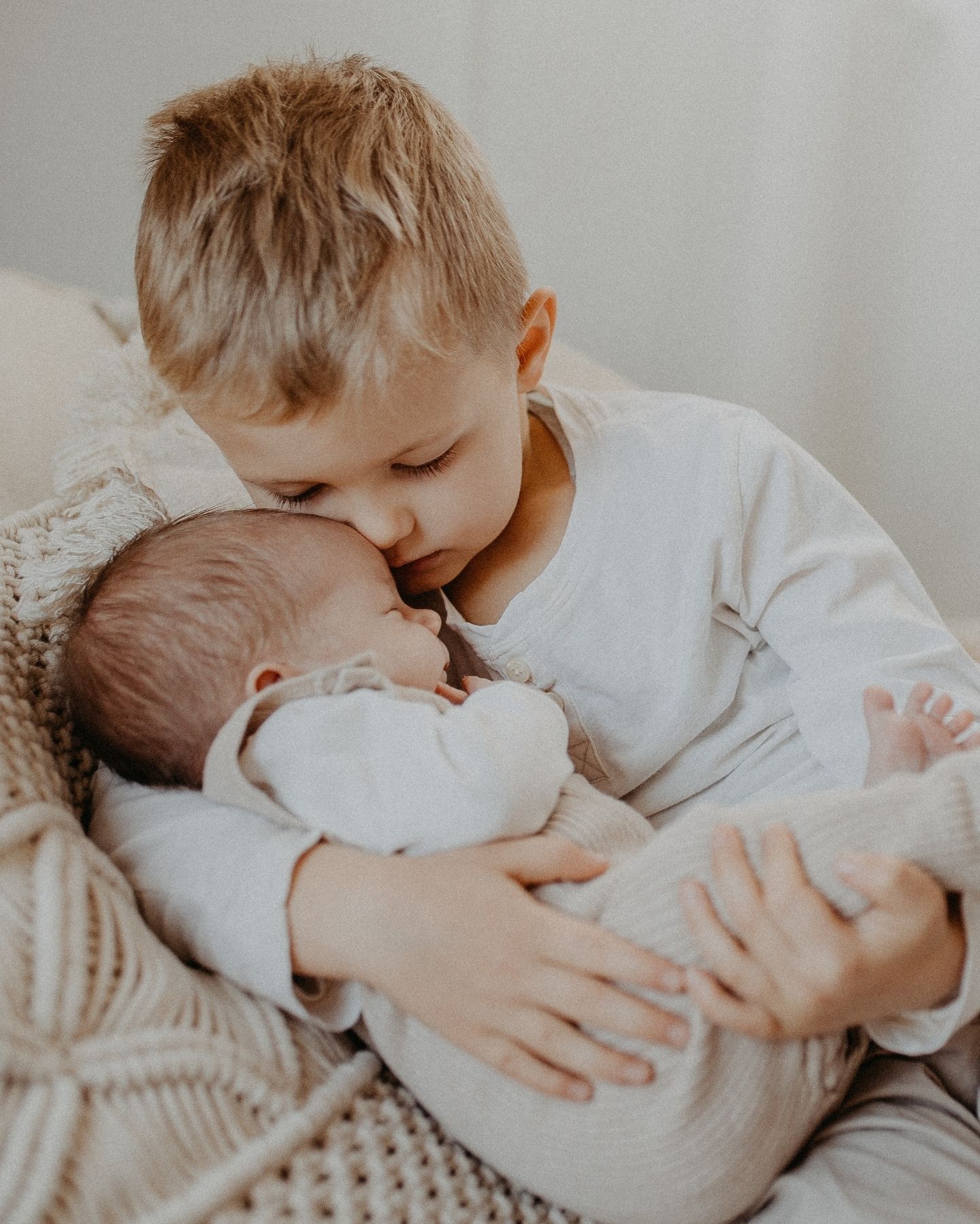 Baby im Arm des größeren Bruders. 